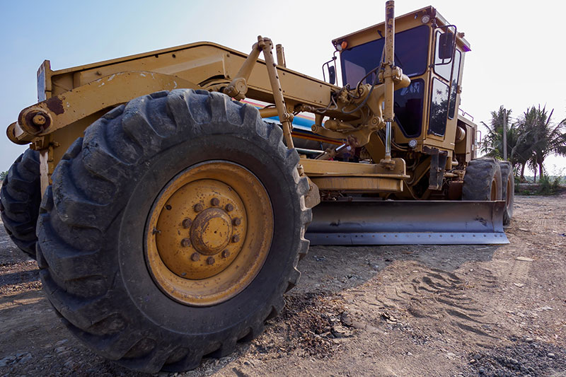 Construction site machine grading ground fill dirt in central Florida