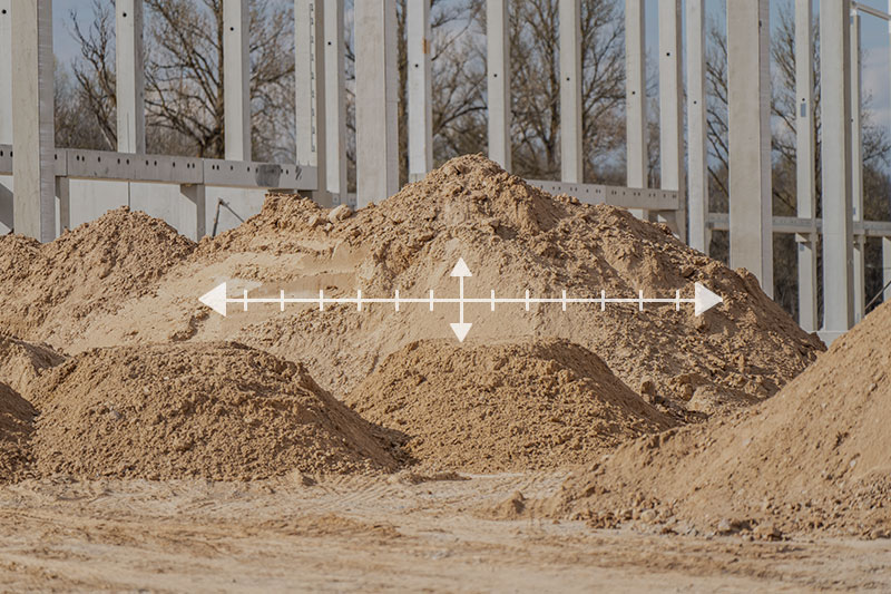 Multiple piles of masonry sand with overlaid measuring lines at a construction site in Lakewood Ranch, FL